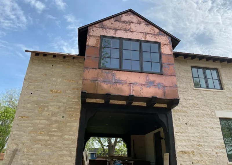 Copper metal panel facade on a stone building for Roof Repair in Pennfield