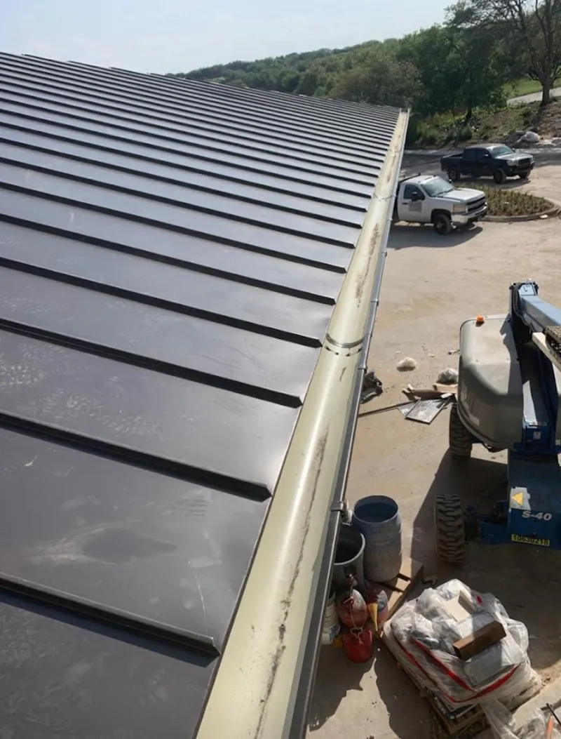 Standing seam panel and gutter detail on a metal roofing jobsite in Pennfield